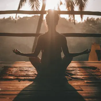 Persona che pratica yoga all'aperto al tramonto